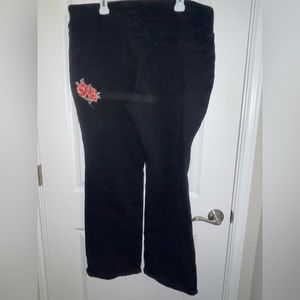 Black plus size stretch pull upcjeans with rose appliqué.